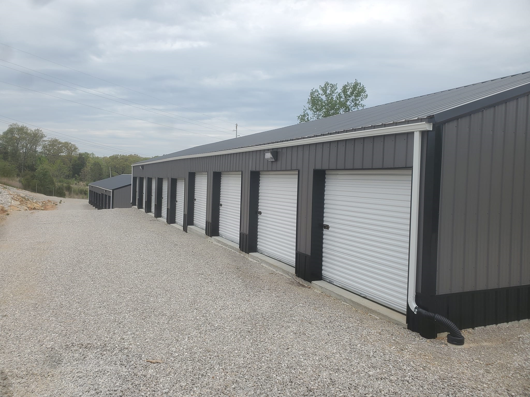 Two storage unit buildings viewed from a side angle, each within a secure lot.